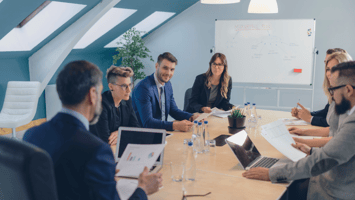 Professional meeting with Australian employers reviewing migration strategy and visa program data