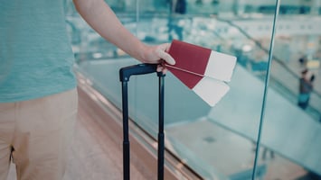 Skilled worker holding passport and boarding pass representing international recruitment and relocation