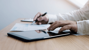 Business professional reviewing charts and data with tablet during a audit check