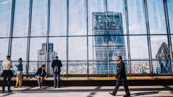 Corporate professionals networking in a modern building with city skyline in the background